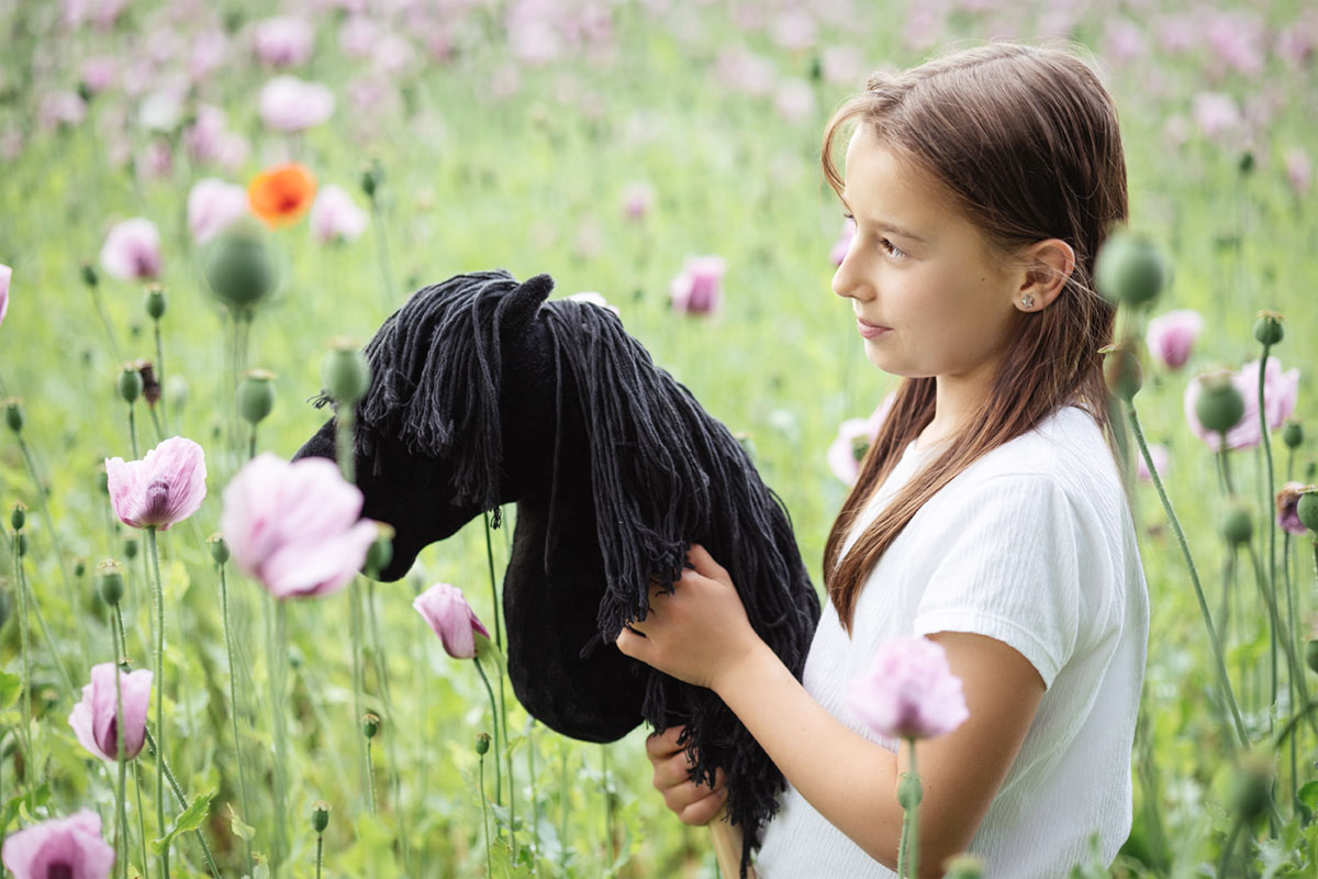 Mädchen mit Pony Mädchen mit Pony im Mohnblumenfeld
